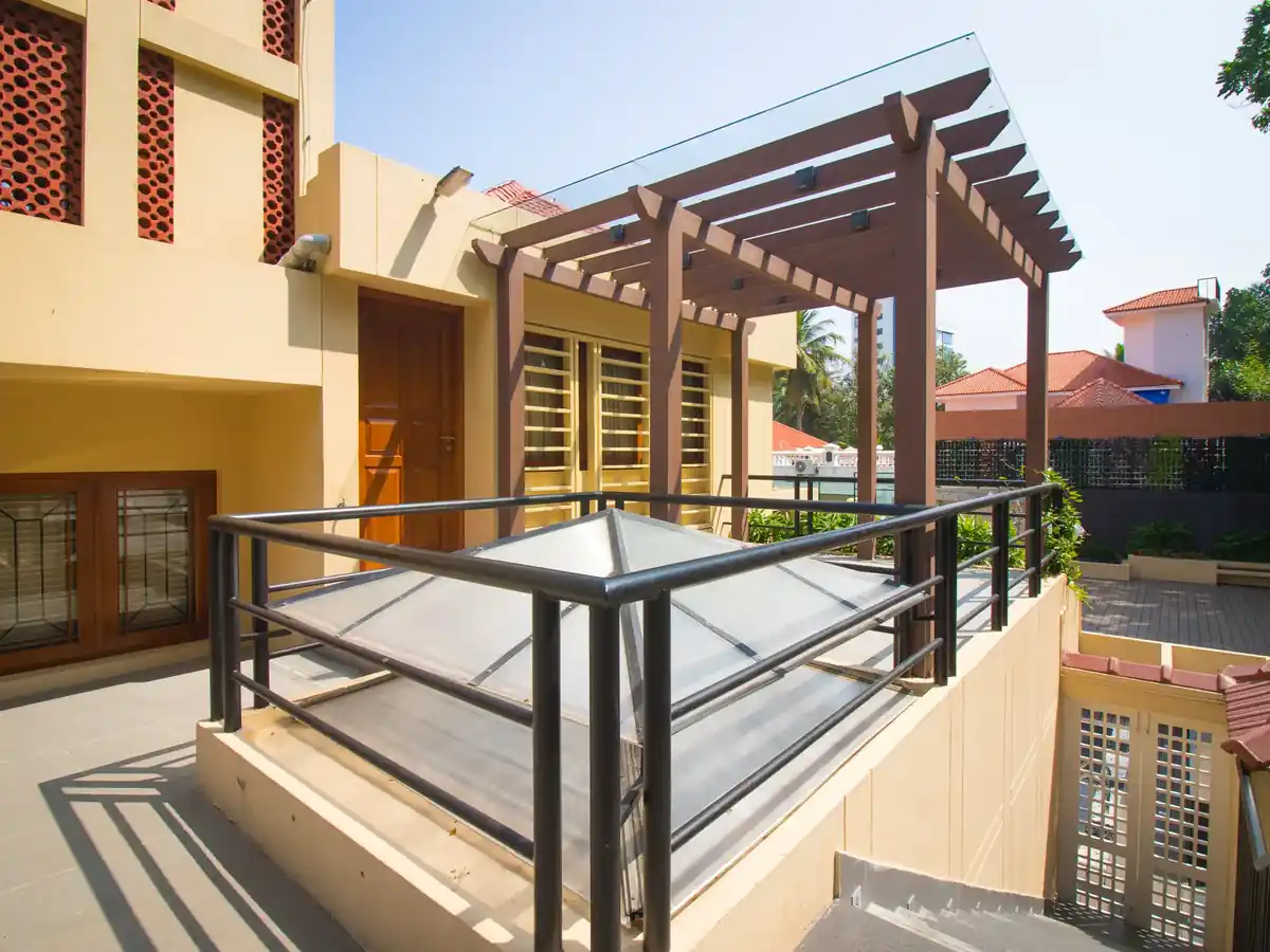 Roof terrace with a glazed pyramid skylight over the stairwell and terracotta jaali blocks in the wall